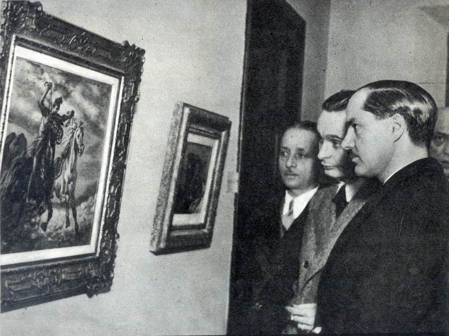 S. E. Il Ministro Pavolini davanti a un quadro di De Chirico alla 
